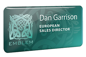 A blue plastic badge with white writing on